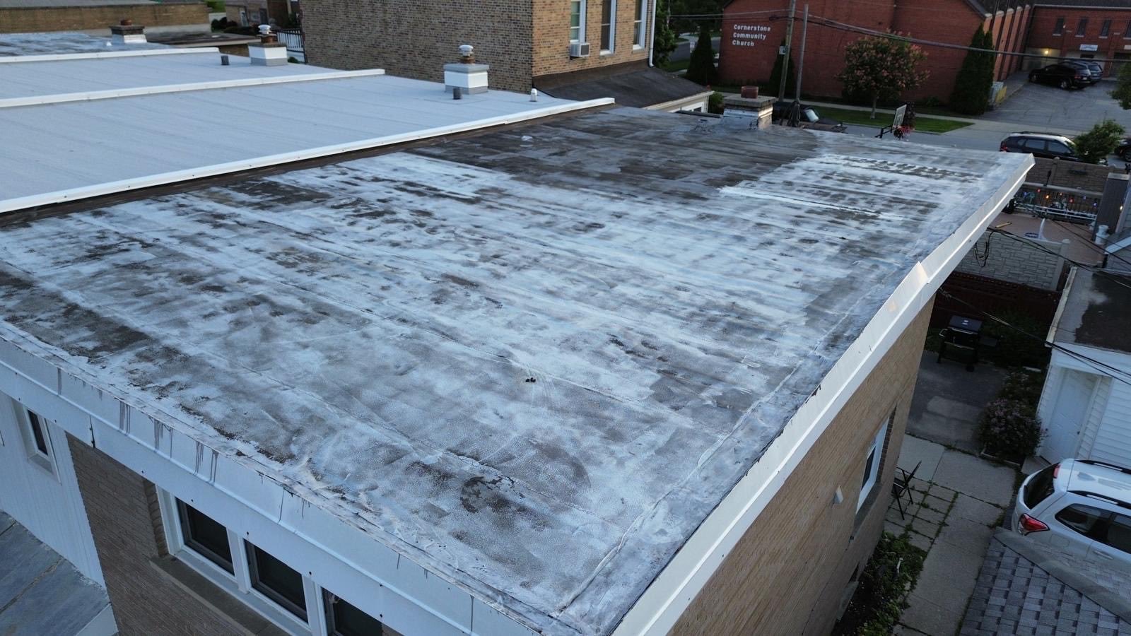 Aerial view of commercial flat roof with fresh silver reflective coating applied