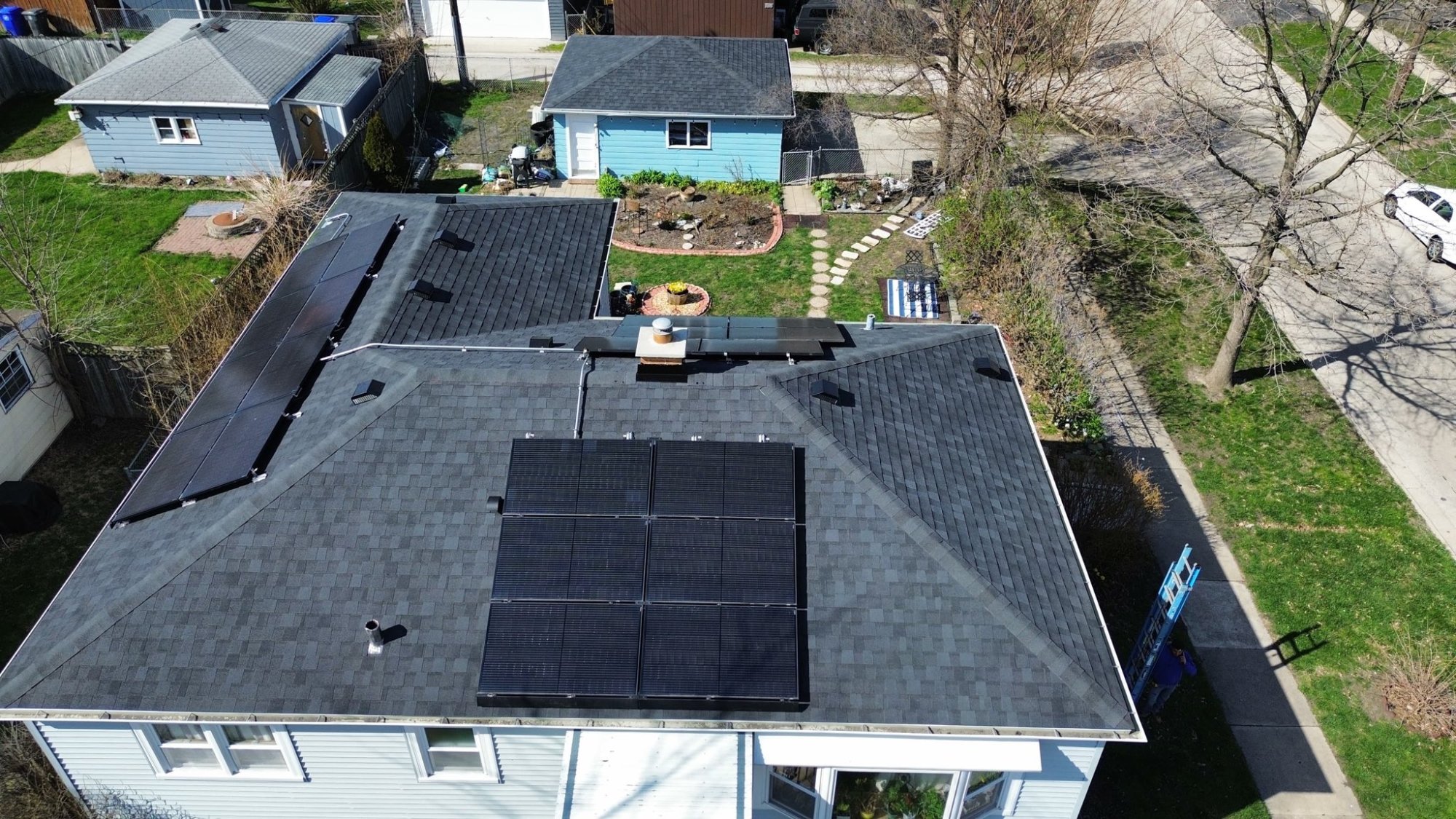 Aerial view of completed dark shingle roof with solar panel installation